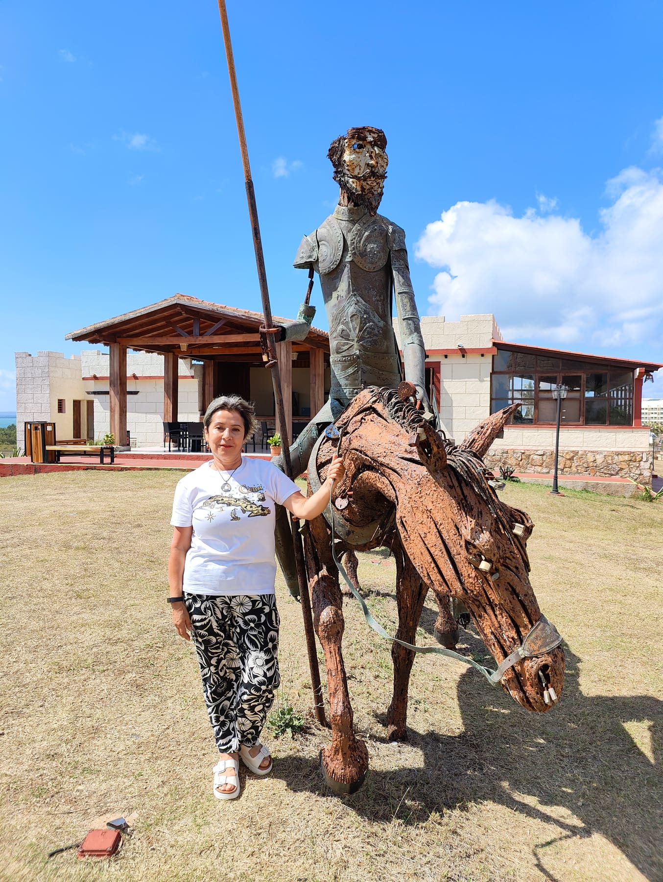 Beatriz junto a una estatua de Don Quijote y su caballo