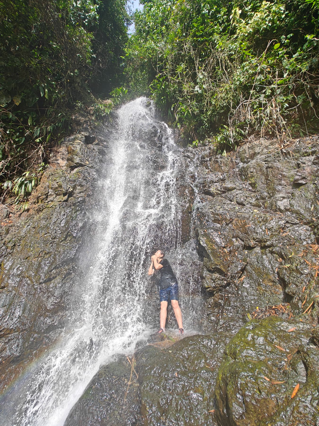 Beatriz bajo una cascada en medio de la selva