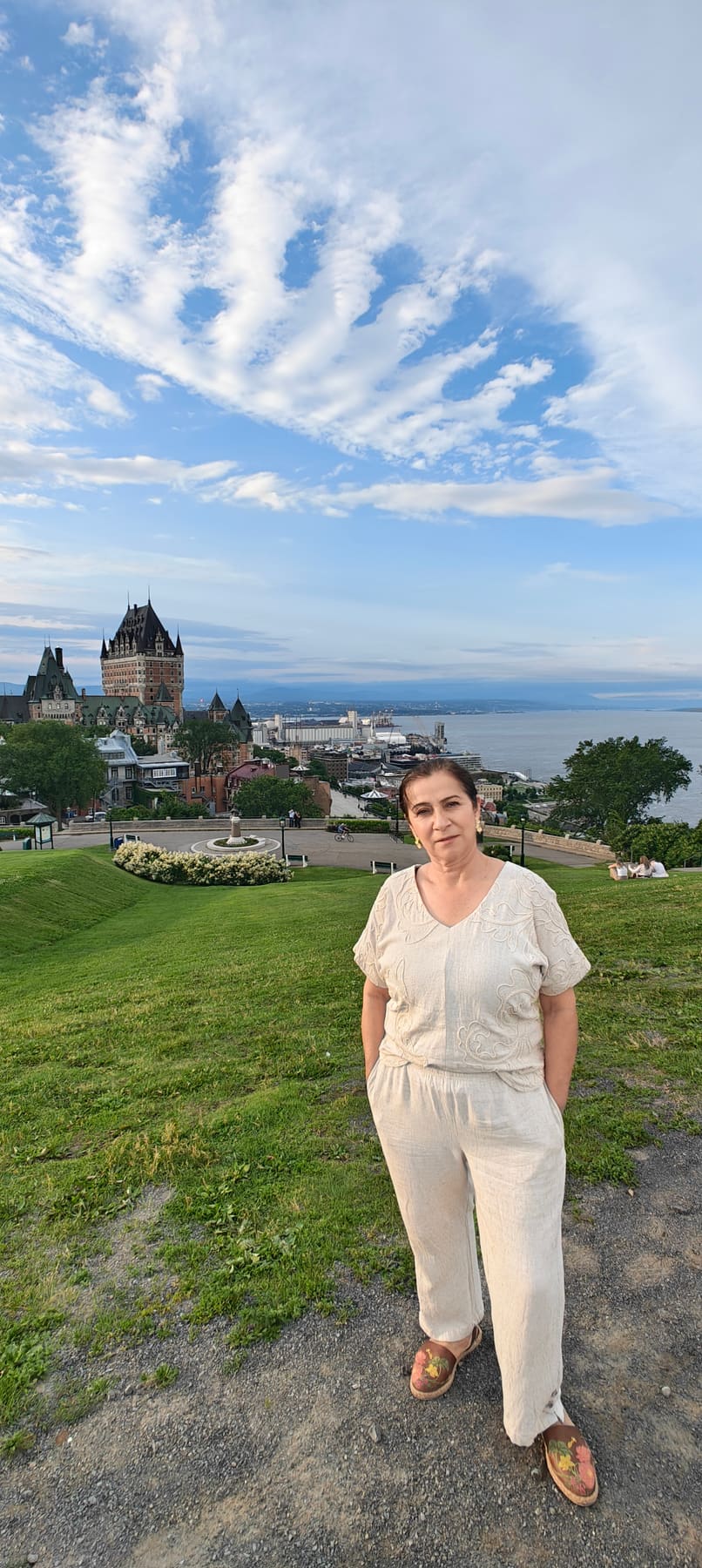 Beatriz frente a un castillo junto al río, en Quebec