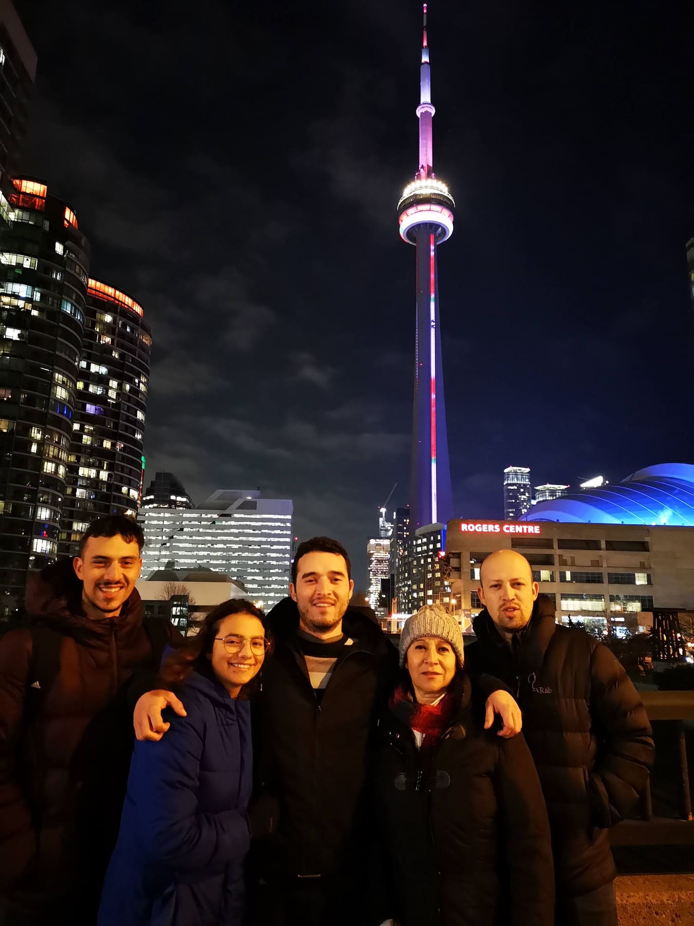 Beatriz con sus hijos de noche, con una torre iluminada de fondo