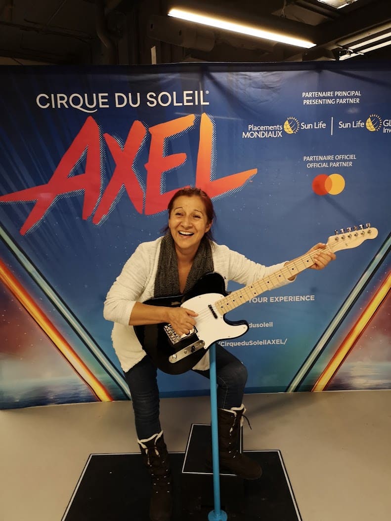 Beatriz sonriendo con una guitarra eléctrica en el evento de Cirque du Soleil Axel