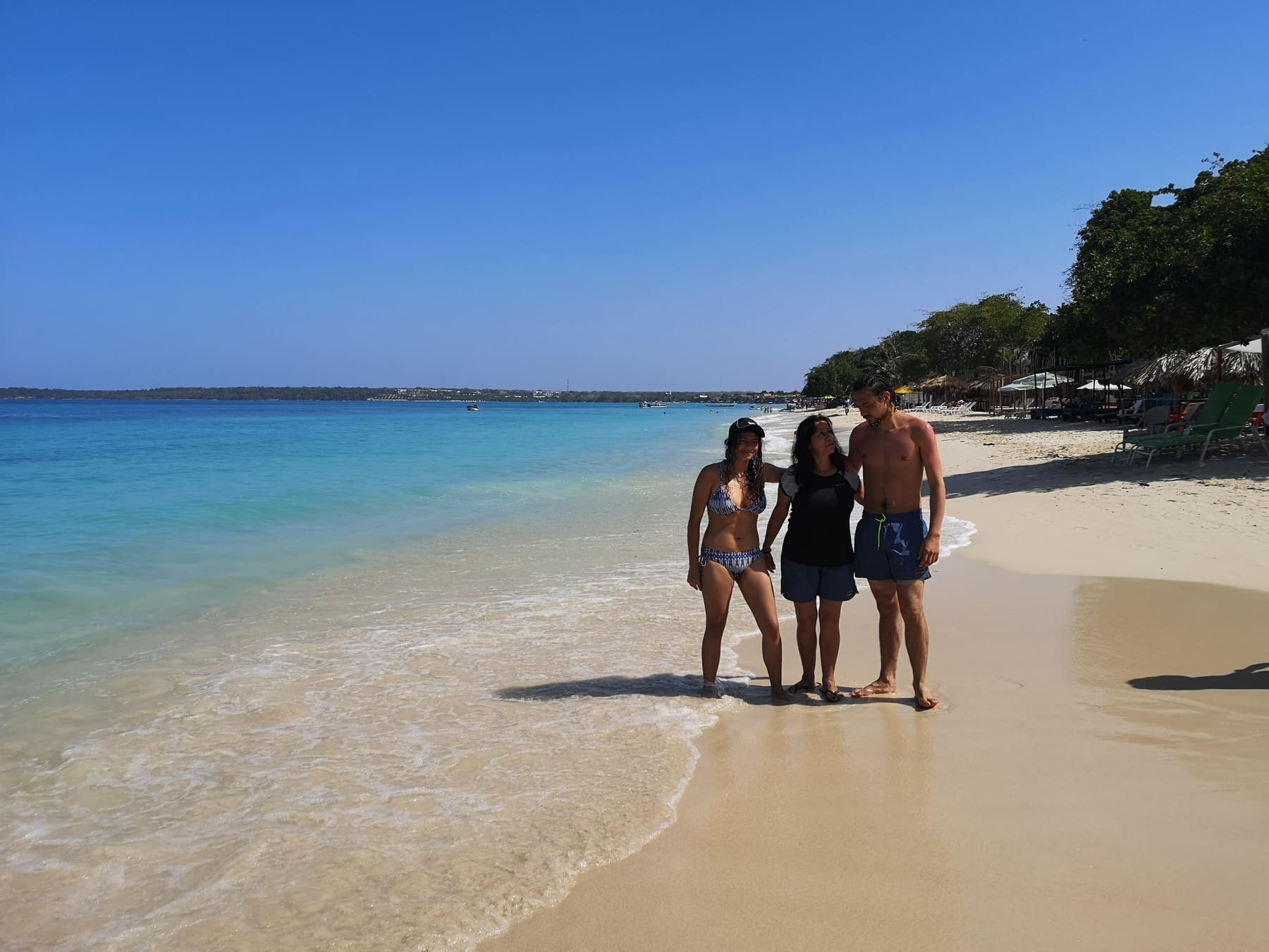 Beatriz con dos de sus hijos en una playa caribeña